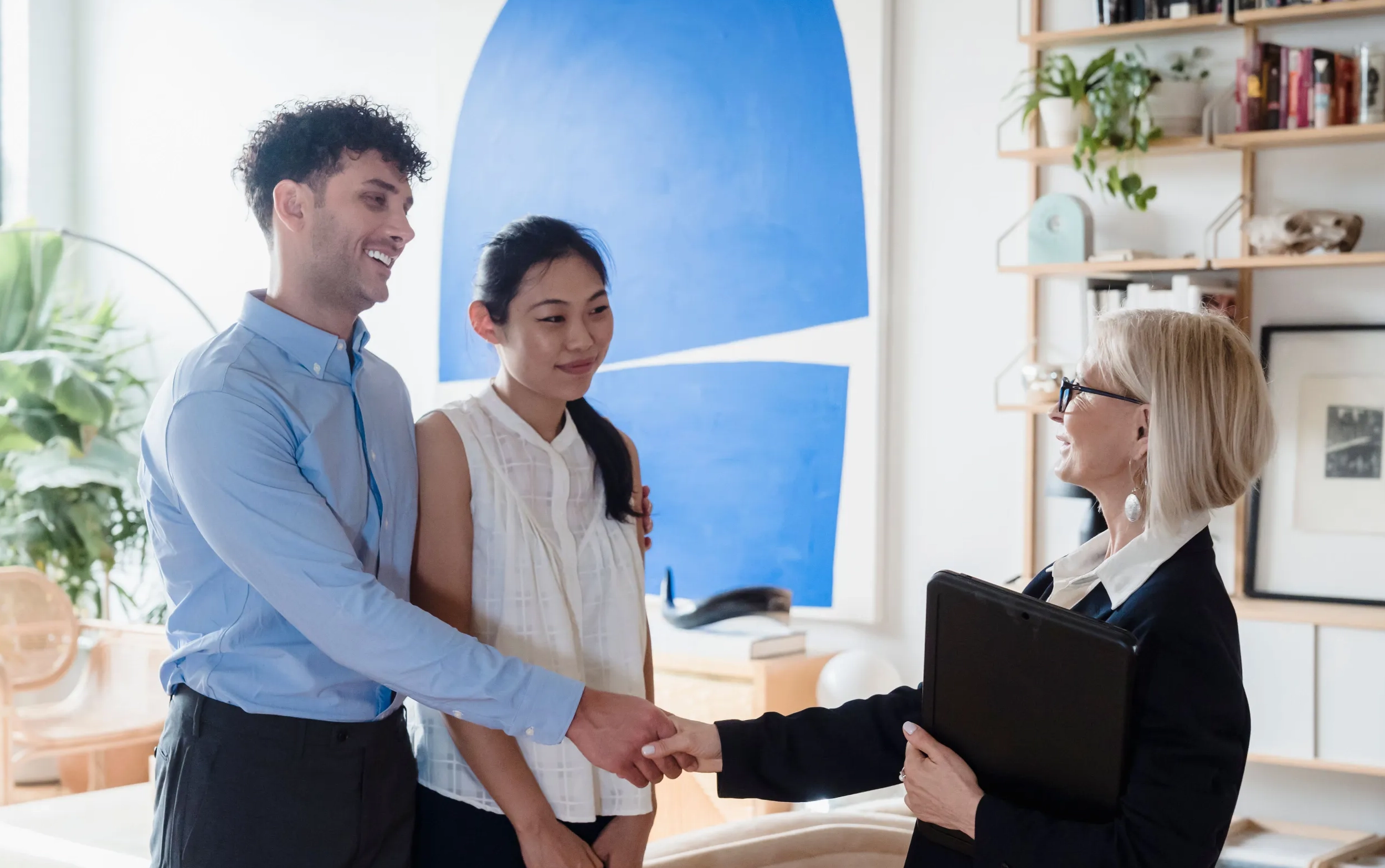 A couple shaking hands with their agent